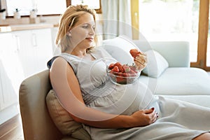 Pregnant woman eating strawberries