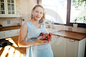 Pregnant woman eating strawberries