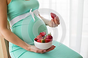 Pregnant woman eating strawberries