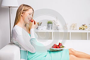 Pregnant woman eating strawberries