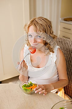 Pregnant woman eats vegetable salad
