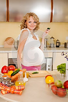 Pregnant woman eats vegetable salad at home