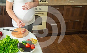 A pregnant woman eats vegetables and fruits. Selective focus