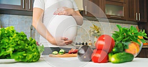 A pregnant woman eats vegetables and fruits. Selective focus