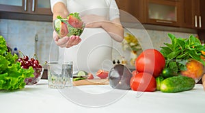 A pregnant woman eats vegetables and fruits. Selective focus