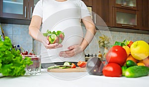 A pregnant woman eats vegetables and fruits. Selective focus