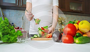 A pregnant woman eats vegetables and fruits. Selective focus