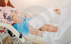 Pregnant woman with electrocardiograph check up for her baby.