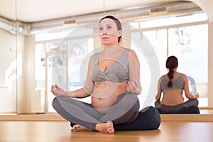 Pregnant woman is engaged in yoga. Easy Pose or Sukhasana