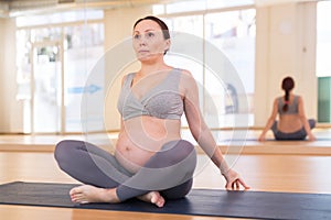 Pregnant woman is engaged in yoga. Easy pose or Sukhasana