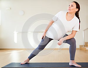 Pregnant woman is engaged in yoga. Extended Side Angle or Utthita Parsvakonasana