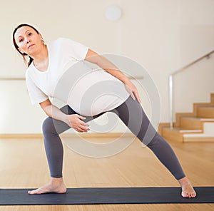 Pregnant woman is engaged in yoga. Extended Side Angle or Utthita Parsvakonasana