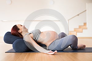pregnant woman is engaged in yoga. Reclined Goddess Pose or Supta Baddha Konasana