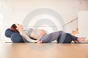 pregnant woman is engaged in yoga. Reclined Goddess Pose or Supta Baddha Konasana