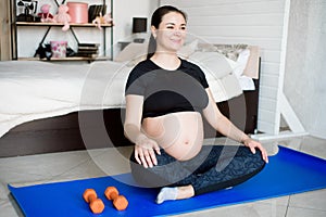 Pregnant woman exercing yoga at home. Pregnancy yoga and fitness.