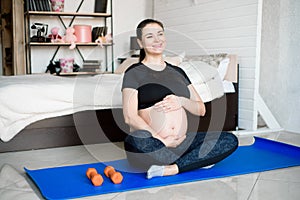 Pregnant woman exercing yoga at home. Pregnancy yoga and fitness.