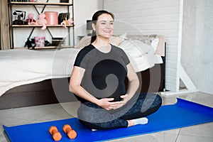 Pregnant woman exercing yoga at home. Pregnancy yoga and fitness.