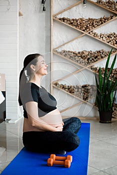 Pregnant woman exercing yoga at home. Pregnancy yoga and fitness.