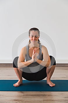Pregnant woman on exercise mat in prenatal yoga posture