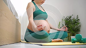 A pregnant woman is exercising with breath. Concept of a healthy lifestyle during pregnancy.