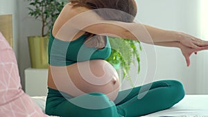 Pregnant woman is exercising with dumbbells. Healthy lifestyle during pregnancy. Sports activities