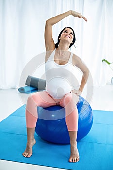 Pregnant woman exercising on exercise ball