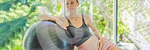 Pregnant woman exercising on fitball at home. Pregnant woman doing relax exercises with a fitness pilates ball. Against