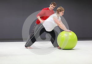Pregnant woman exercising with trainer