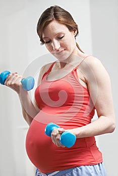 Pregnant Woman Exercising With Weights