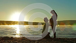 A Pregnant Woman And Expectant Father On Lake