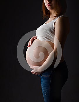 Pregnant woman, expectant mother on black background,