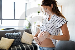 Pregnant woman expecting baby and taking care of skin and stretch marks