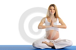 Pregnant woman with eyes closed practicing yoga