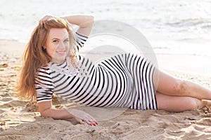 Pregnant woman in fashion dress on beach