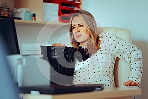 Pregnant Woman Feeling Nauseated at the Office Desk photo