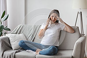 Pregnant Woman Feeling Unwell While Talking On Cellphone At Home, Having Headache