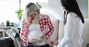 Pregnant woman feels pain sitting near female doctor