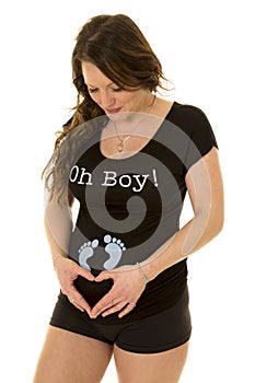 Pregnant woman with feet on shirt make heart with hands