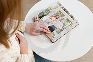 Pregnant woman flips through photo book from family pregnancy photo shoot