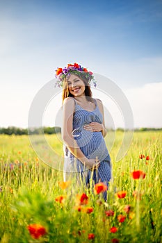 Pregnant woman in a flowering poppy field