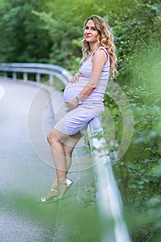 Pregnant woman on forest background