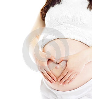 Pregnant woman forming heart out of her hands on her baby bump