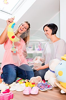 Pregnant woman with friend in prospective baby room