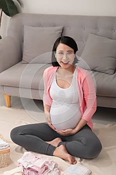 Pregnant woman is getting ready for the maternity hospital, packing baby clothes