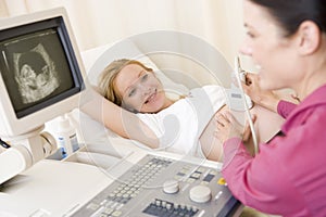 Pregnant woman getting ultrasound from doctor