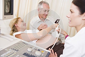 Pregnant woman getting ultrasound from doctor