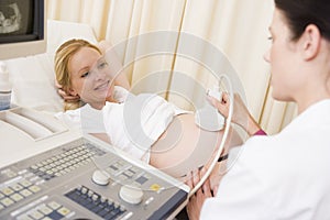 Pregnant woman getting ultrasound from doctor