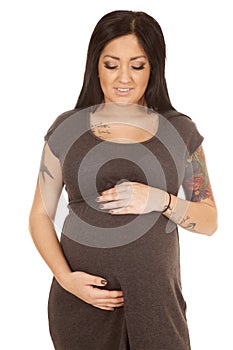 Pregnant woman gray dress front hold belly tattoos