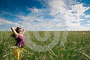 Pregnant woman on green grass field under blue sky