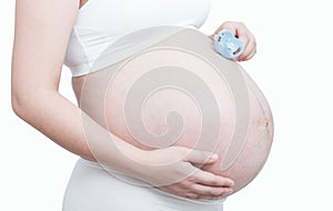 Pregnant woman hand holding pacifier for the unborn baby on whit